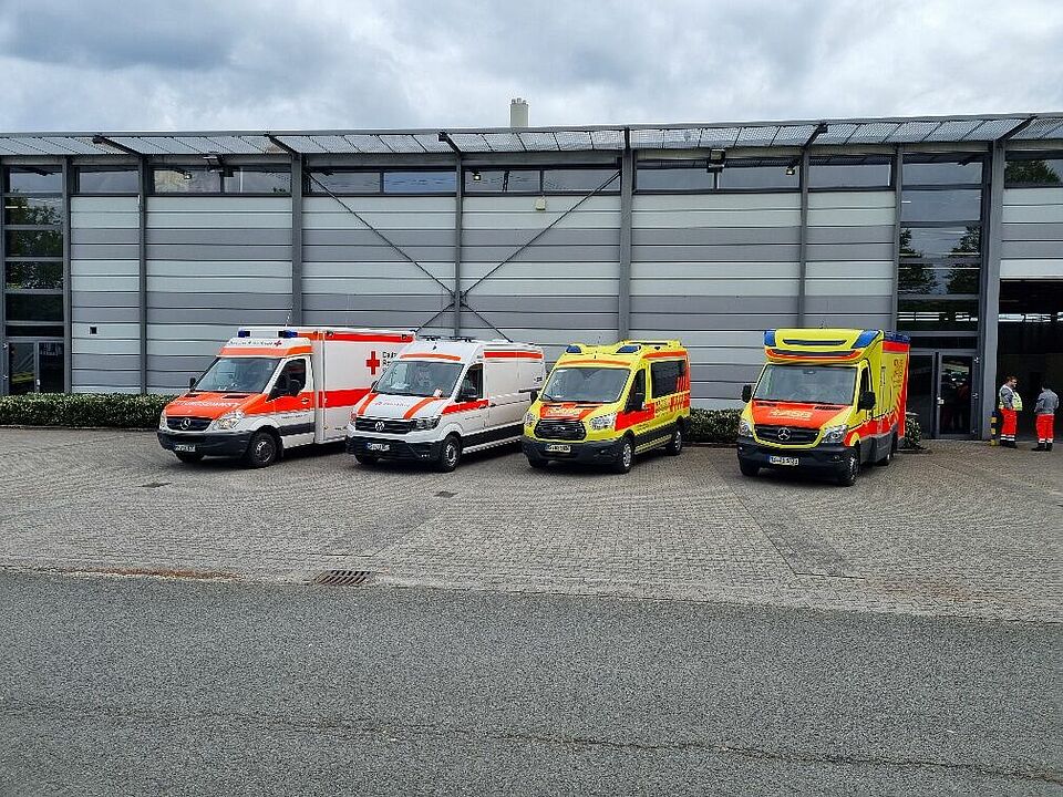 Fahrzeuge Vier Einsatzfahrzeuge vor einer Halle