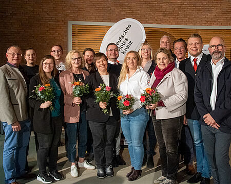 15 Personen als Gruppe vor einer Klinkerwand
