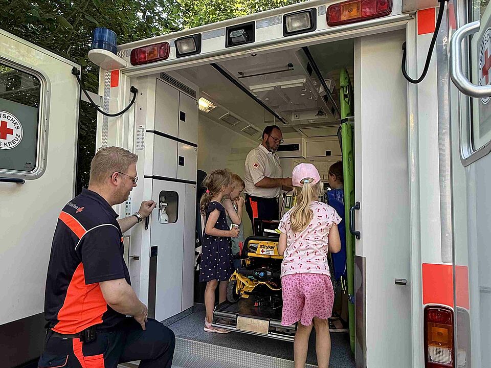 Lummerland Krankenwagen Vier Kinder und zwei Einsatzkräfte in einem DRK-Krankenwagen