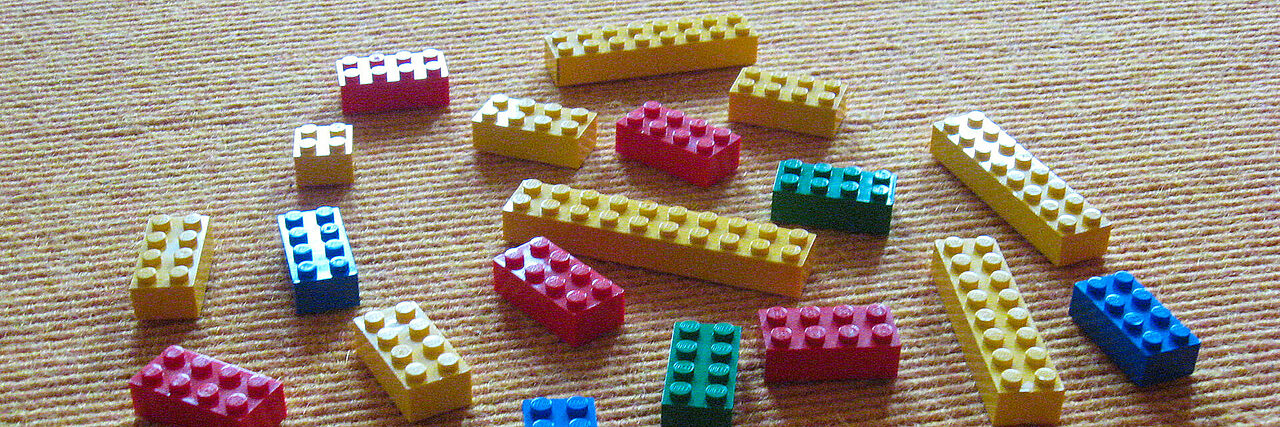 Bunte Legoklötzchen auf gelbem Teppichboden