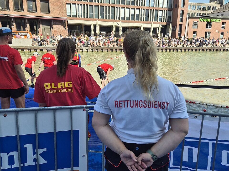 Rettungssanitäterin in Einsatzkleidung vor der Schwimmstrecke