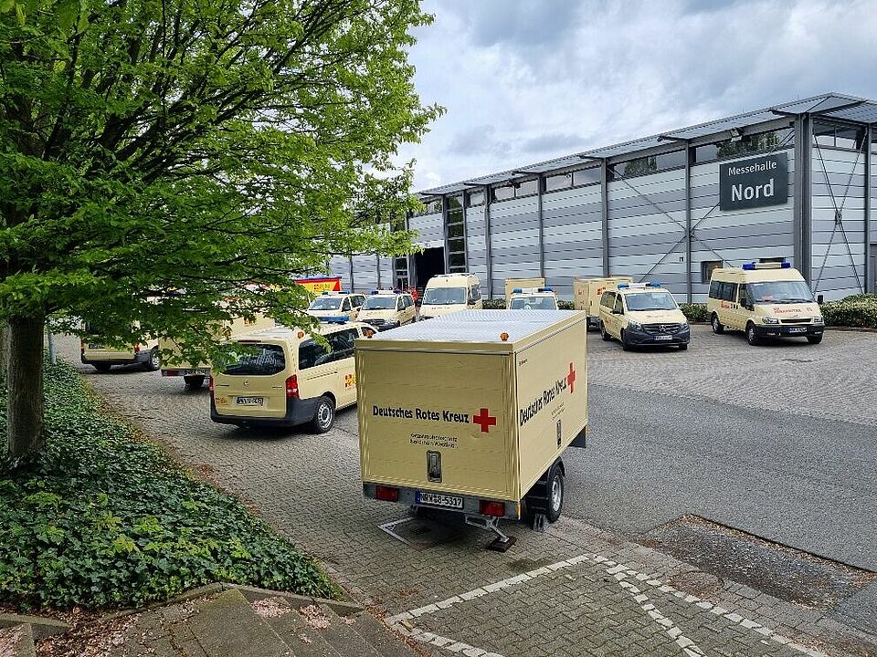 Betreuungsdienst Fahrzeuge Betreuungsfahrzeuge und ein Anhänger vor einer Halle