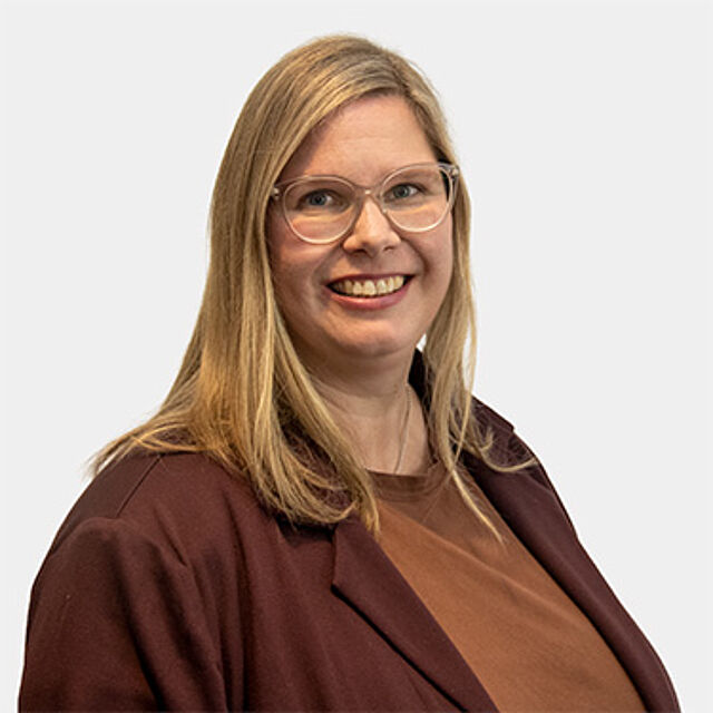 Eine Frau mit blonden langen Haaren und Brille