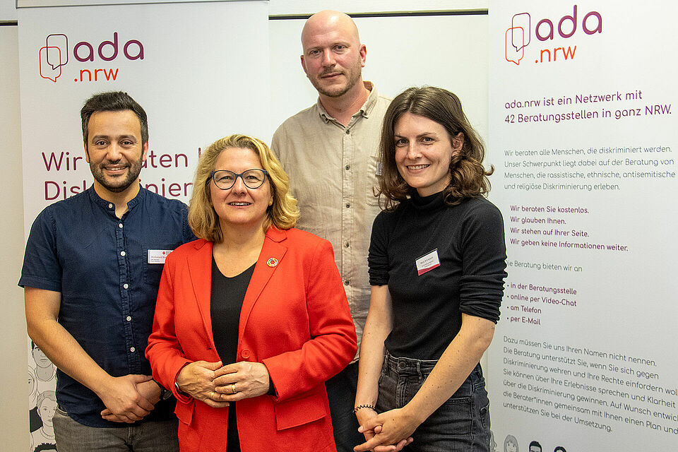 Vier Personen stehen vor Aufstellern des ADA Netzwerks NRW
