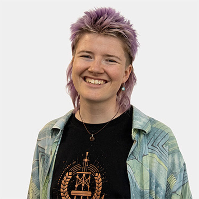 Eine Person, die ein schwarzes T-Shirt und ein Hemd trägt.