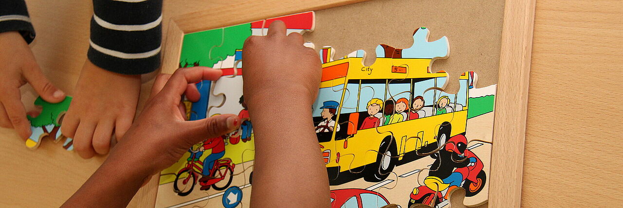 Ein Puzzle mit Kinderhänden