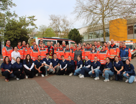 Gruppenfoto von den Personen in Einsatzkleidung (hinten) und Personen in Pflegekleidung (vorne)