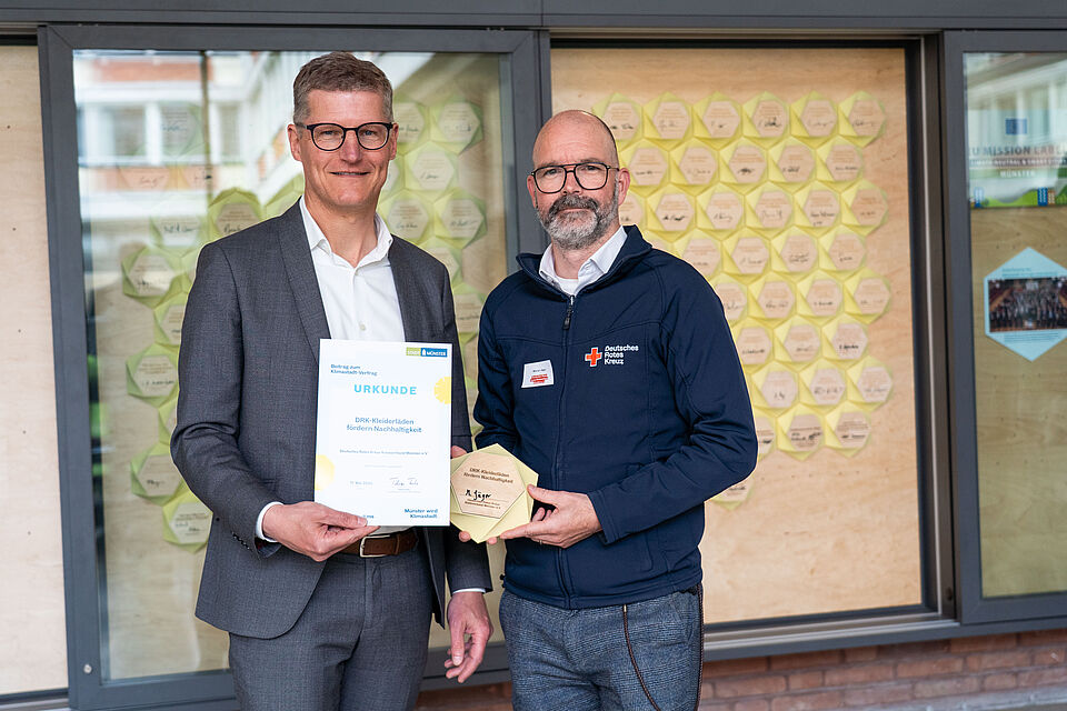 Klimstadt-Vertrag Zwei Männer mit einer Urkunde und einer Plakette