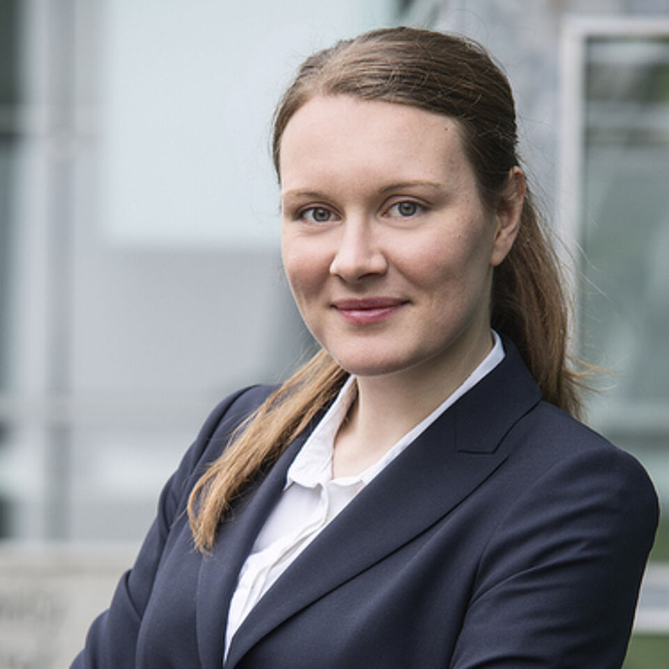 Frau mit blonden Haaren und dunklem Blazer