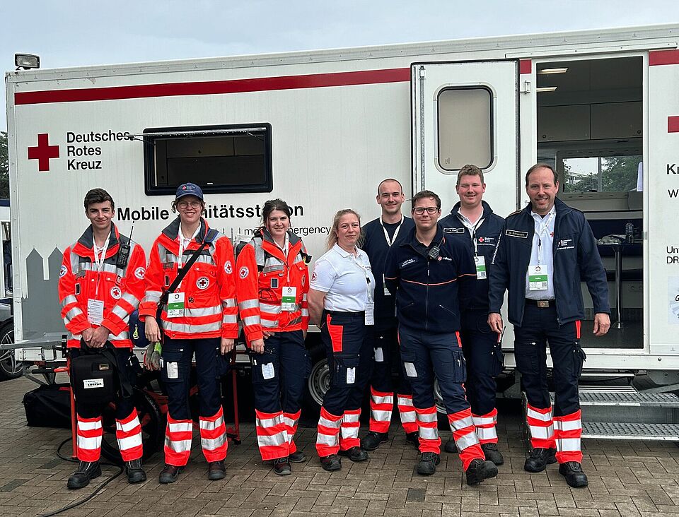 Gruppenbild Gruppenbild mit acht Personen in Einsatzkleidung vor der Unfallhilfsstation