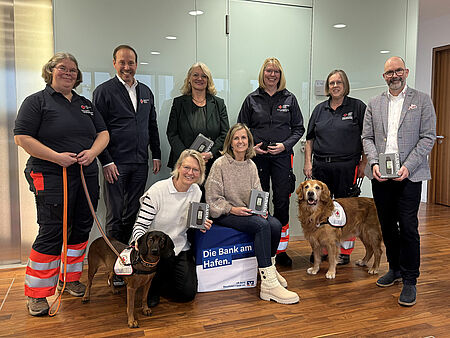 Gruppenbild Spendenübergabe Ein Gruppenbild mit acht Personen und zwei Hunden