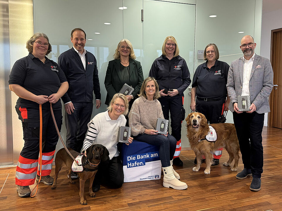 Gruppenbild Spendenübergabe Ein Gruppenbild mit acht Personen und zwei Hunden
