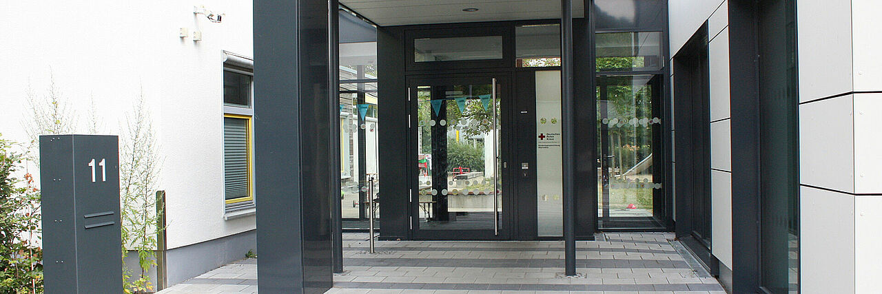Meerwiese Eingang in ein modernes Gebäude mit großen Glastüren und Fenstern.