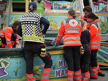 Mehrere Einsatzkräfte und eine Übungsbeobachtung an einem Fahrgeschäft